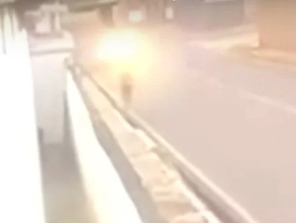 Foto colorida de mulher andando na riua e casso se aproximando - Metrópoles