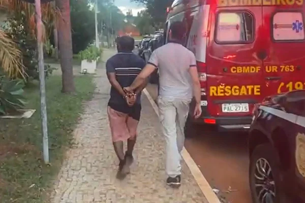 homem algemado é levado por agente