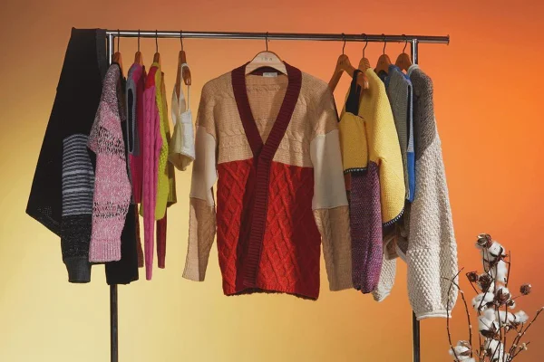 Roupas de tricô penduradas em arara