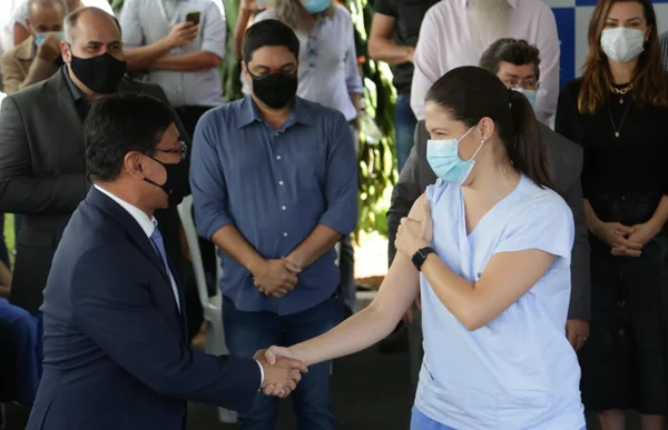 Osnei Okumoto e a enfermeira Lígia Dantas durante vacinação contra Covid019 no DF