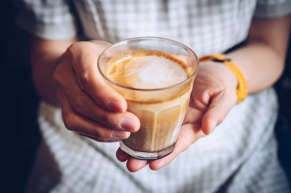 Foto colorida de mãos segurando xícara de café - Metrópoles