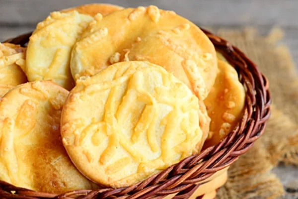 Na foto vemos um cesto com biscoitos amarelos em rodelas