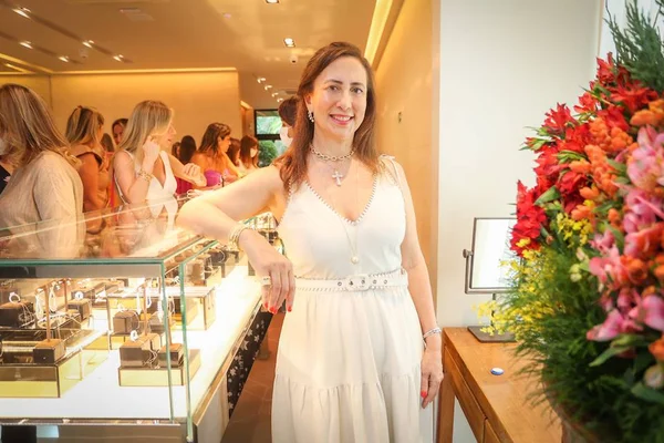 Mulher com a mão na cintura com outras mulheres ao fundo