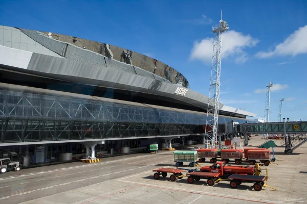 Aeroporto de Pernambuco ao fundo da imagem e carros de manutenção de pista.