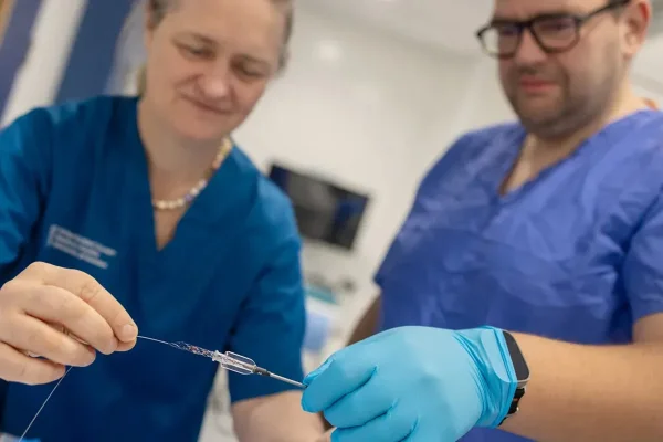 Imagem mostra dois médicos segurando algo parecido com um fio. professora Iris Grunwald demonstra a tecnologia. Metrópoles