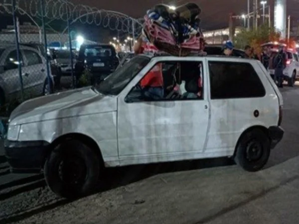 Foto colorida mostra Fiat Uno branco estacionado.