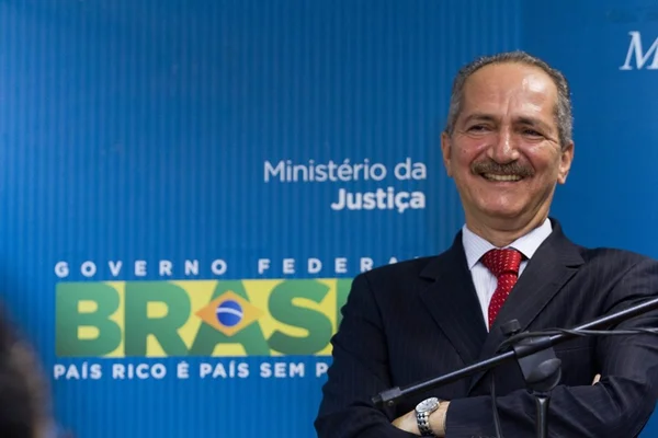 Aldo Rebelo sorrindo, de braços cruzados