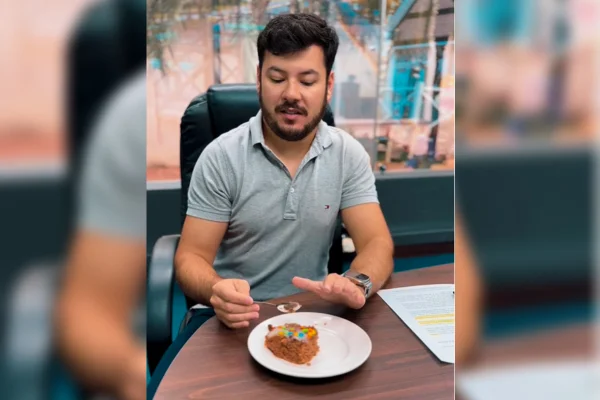 Imagem colorida, prefeito Diego Francisco comendo bolo - Metrópoles