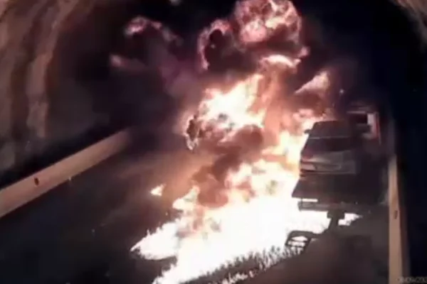 Imagem colorida de carro pegando fogo em túnel. Metrópoles