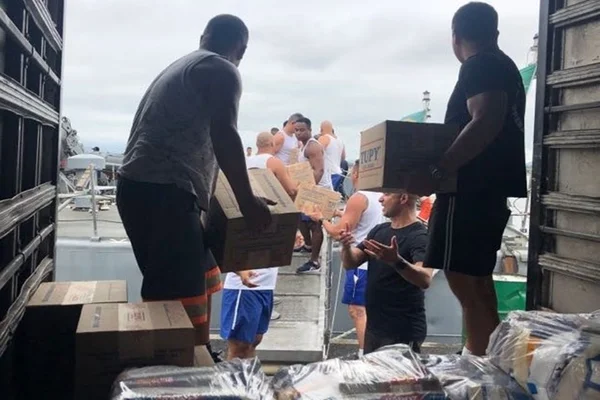 Foto colorida de marinheiros com doações para desabrigados em São Paulo