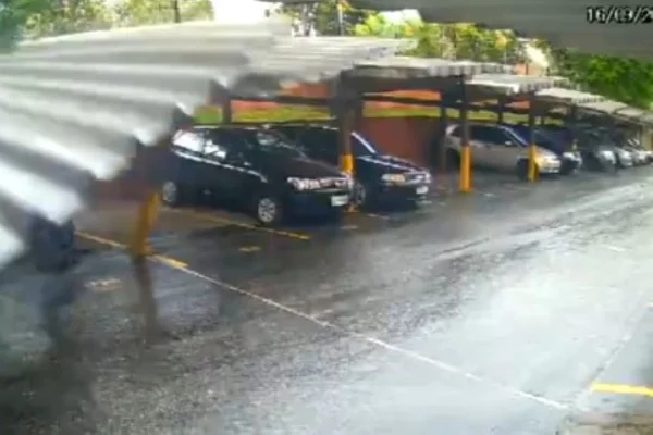 Imagem colorida de telhado desabando em cima de carros. Metrópoles