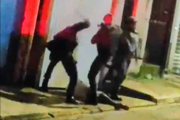 Imagem colorida de PMs espancando homem