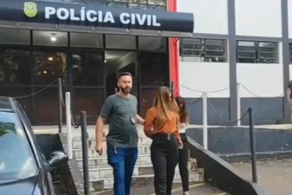 Imagem colorida de mulheres algemadas deixando delegacia. Metrópoles