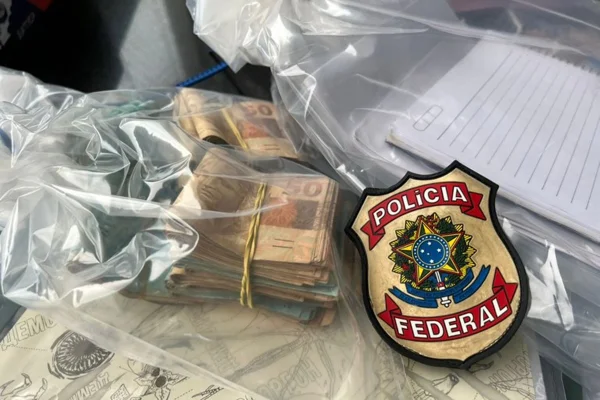 imagem colorida de maços de dinheiro e um distintivo da Polícia Federal