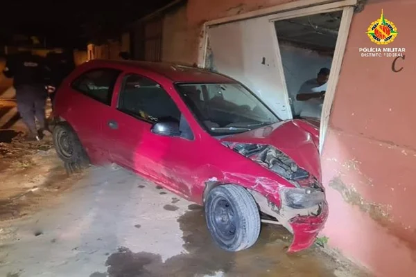 Imagem colorida mostra carro vermelho amassado contra parede