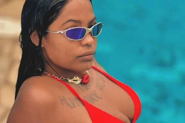 Imagem colorida de mulher usando biquíni e óculos, em piscina - Metrópoles