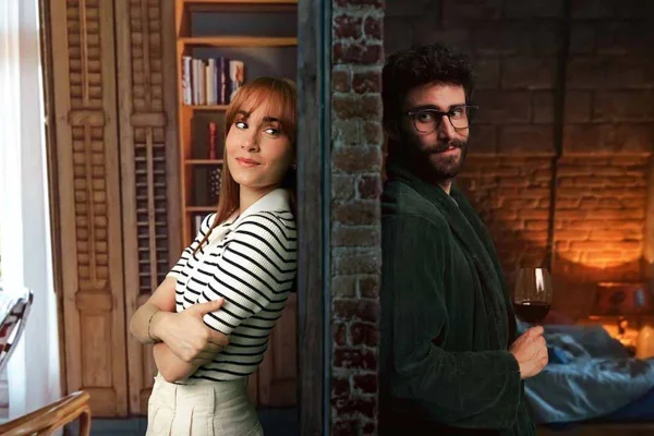 Uma mulher ruiva e um homem dividios por uma parede no filme Uma Parede Entre Nós que está disponível na Netflix - Metrópoles
