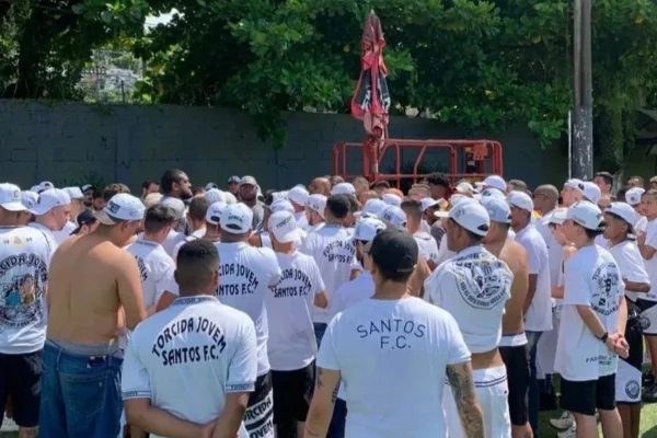 Imagem mostra torcedores uniformizados em CT do Santos - Metrópoles