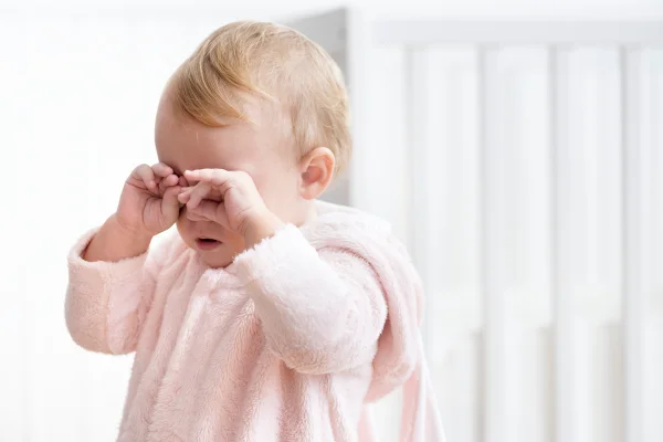 Imagem colorida de um bebê coçando os olhos - Metrópoles