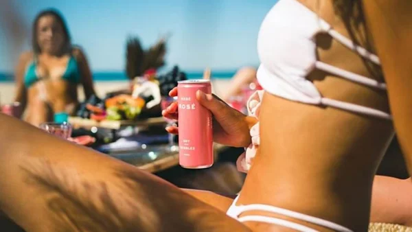 Mulher de biquíni segurando vinho em lata