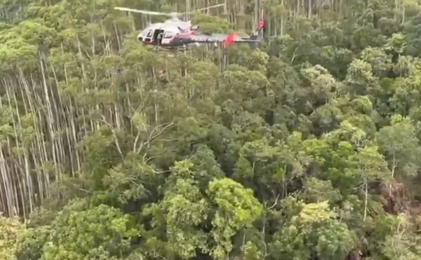 Foto colorida de helicóptero da PMSP sobrevoando área onde helicóptero caiu
