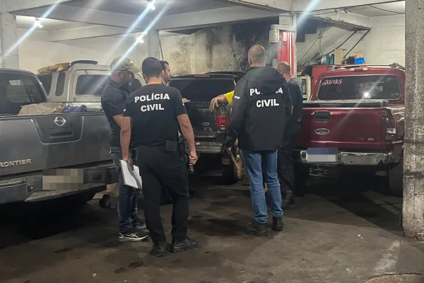 Policiais em garagem com caminhonetes