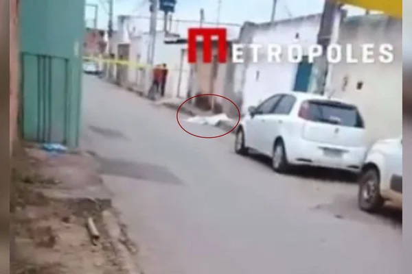 Imagem colorida de um corpo coberto no chão - Metrópoles
