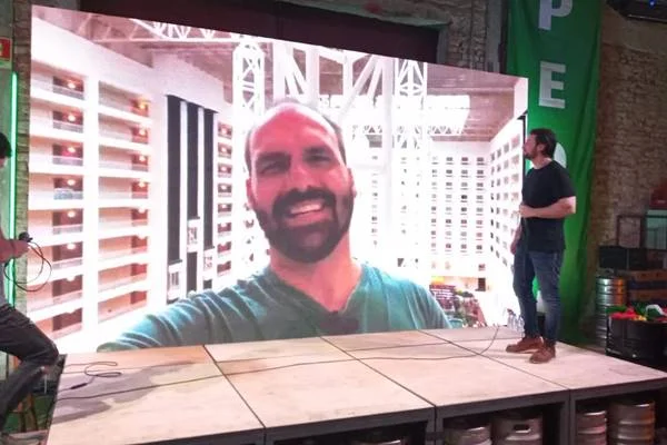Fotografia colorida de homem sorrindo em telão