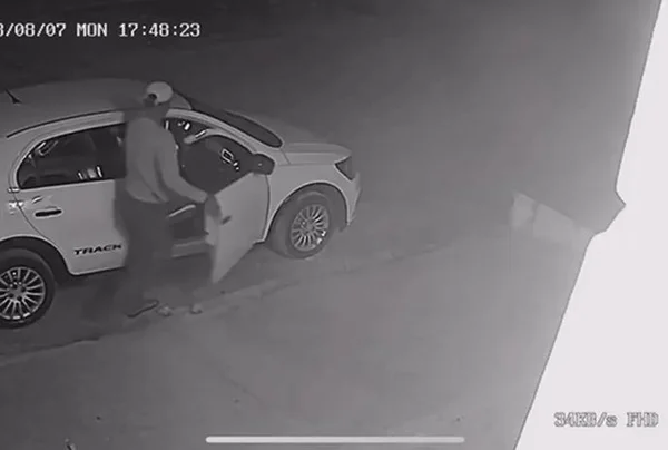 Imagem em preto e branco de criminoso roubando o carro - Metrópoles