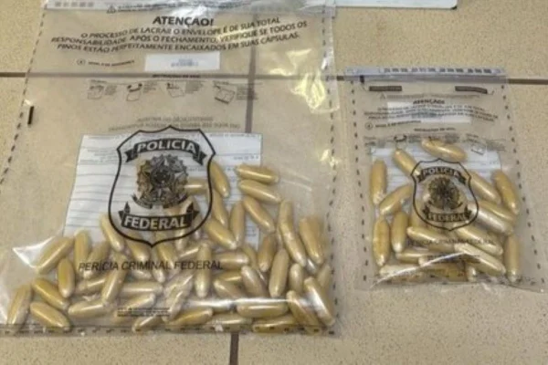 Imagens coloridas mostram cápsulas de cocaína dentro de plásticos com logo da Polícia Federal