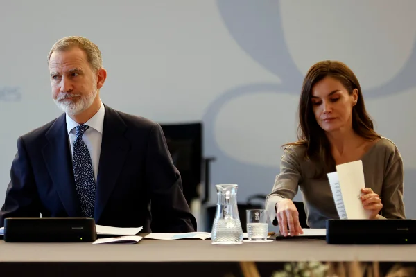 Foto colorida de homem e mulher sentados. Eles assinam documentos - Metrópoles