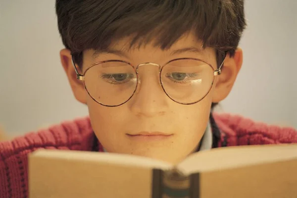 menino de óculos lendo livro