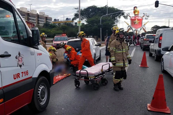 Foto colorida de equipe de resgate do Corpo de Bombeiros do DF atendendo à vítima de acidente em via