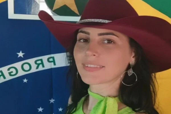 Imagem colorida de Raquel Cattani, filha do deputado estadual Gilberto Cattani (PL), de chapéu e com a bandeira do Brasil ao fundo - Metrópoles