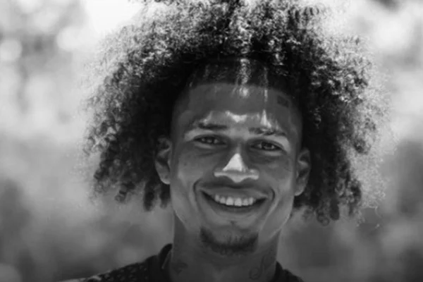 Imagem em preto e branco mostra o jogador Marco Angulo, da LDU, sorrindo | Metrópoles