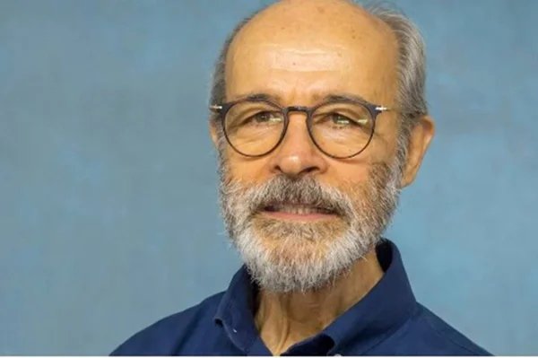 Osmar Prado de óculos e camisa polo azul com fundo azul - Metrópoles