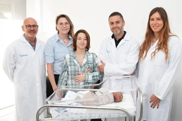 Foto de bebê em hospital rodeado por três médicos e duas mulheres - Metrópoles
