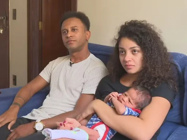 Foto colorido de casal com o filho no colo - Metrópoles