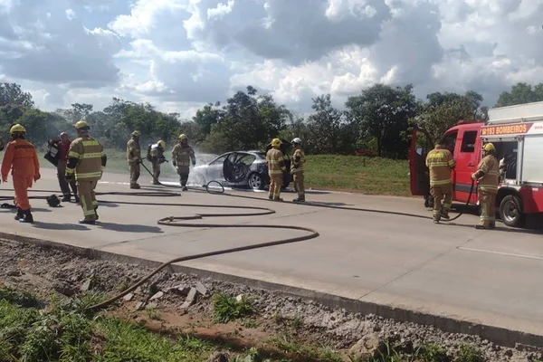 carro ao fundo da imagem com bombeiros em volta