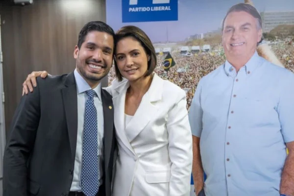 Foto colorida michelle bolsonaro e andré fernandes com Bolsonaro de papelão - Metrópoles