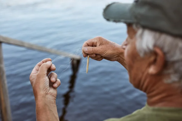 Imagem colorida de homem segurando linha para a pesca - Metrópoles