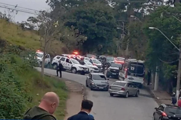 Diversas viaturas da PM e carros em cruzamento de ruas, cercado por vegetação - Metrópoles