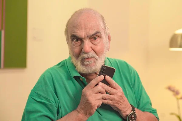 Lima Duarte com celular e blusa verde