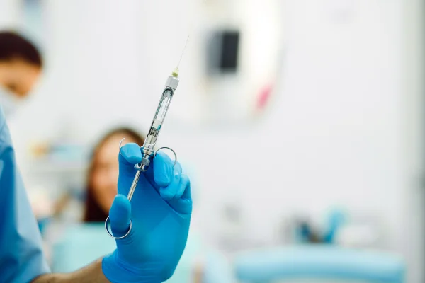Auxiliar de dentista e o paciente na clínica. Metrópoles