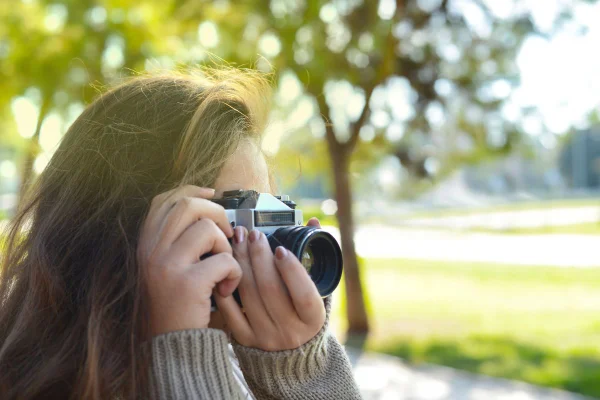 mulher segurando uma máquina fotográfica