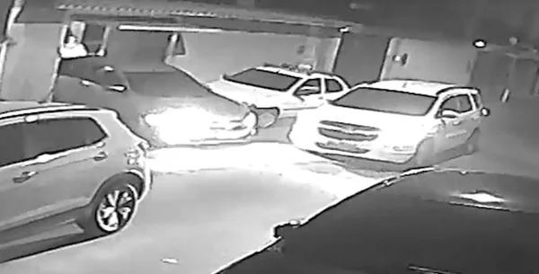 Imagem preto e branco de momento em que assaltantes chegam - Metrópoles