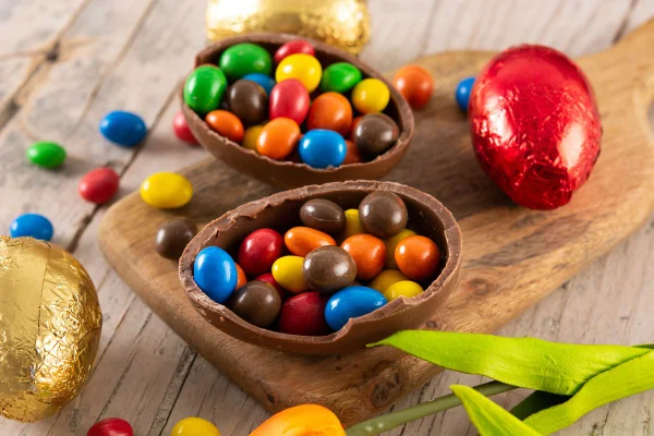 Ovos de Páscoa de chocolate coloridos em mesa de madeira