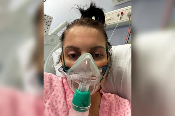 Foto de Nicola Hutchinson no hospital usando um respirador. Metrópoles