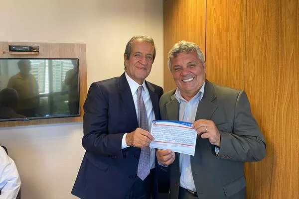 Valdemar da Costa Neto, presidente do PL, segura a ficha de filiação de Alberto Fraga ao lado do próprio político, que sorri. Ambos usam terno - Metrópoles