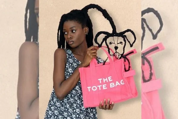 Artista segurando uma bolsa Marc Jacobs